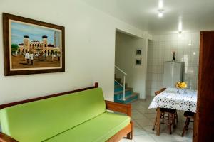salon z zieloną kanapą i stołem w obiekcie Encantada Floripa w mieście Florianópolis