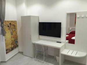 Camera bianca con TV su una scrivania bianca di Picaflor Art & Rooms a Milano