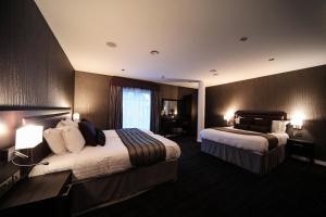 a hotel room with two beds and two lamps at EPIC Apart Hotel - Seel Street in Liverpool