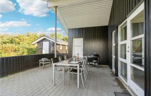 a patio with a table and chairs on it at Awesome Home In Tarm With Sauna in Tarm