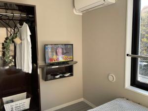 a room with a tv and a bed in a room at COMMA HOUSE Shinjuku 303 in Tokyo