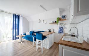 a white kitchen with blue chairs and a blue couch at 1 Bedroom Amazing Apartment In Darlówko in Darłówko