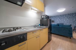 a kitchen with a sink and a stove and a refrigerator at lapis lazuli in Kami-furano