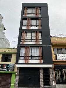 a black and white building with windows at Apartamento de una habitación in Pasto