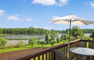 a table with an umbrella on a deck with a lake at Wohnung Templin Ot Dargersdorf in Dargersdorf
