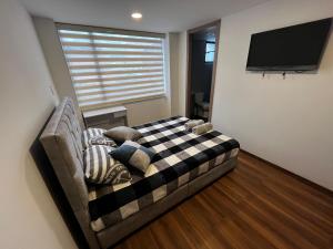 a living room with a couch and a flat screen tv at Apartamento de una habitación in Pasto +4 photos