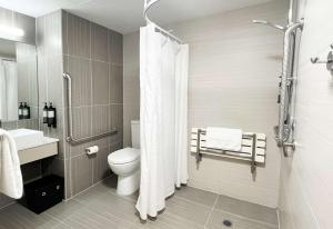 a bathroom with a toilet and a shower at Sudima Auckland Airport in Auckland