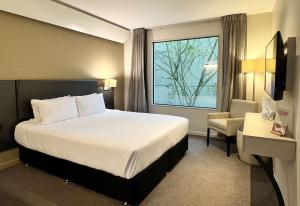 a hotel room with a bed and a window at Sudima Auckland Airport in Auckland