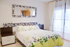 1 dormitorio con cama y espejo en la pared en Apartamento Centrico en Albir, en Albir