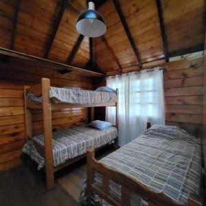 a bedroom with two bunk beds in a cabin at Somos la experiencia LaCruzHouse in Paita