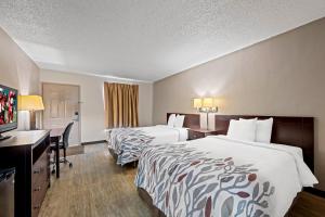 a hotel room with two beds and a desk at Red Roof Inn Abingdon in Abingdon