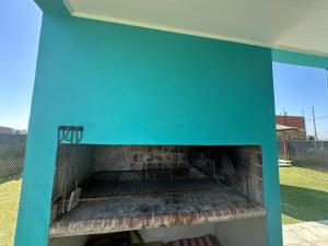 a blue building with a fireplace in a yard at Casa Caelum in Concepción del Uruguay