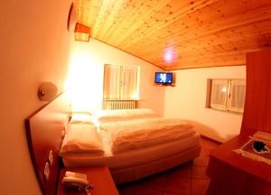 a bedroom with a bed in a room with a wooden ceiling at Hotel Milano in Piazzatorre +13 photos