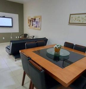a dining room with a wooden table and chairs at Casa temporada com piscina in Caraguatatuba