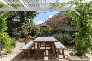 a picnic table under a pergola in a garden at Rose Gold Hideaway in Kings Park +5 photos