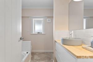a white bathroom with a sink and a toilet at Rose Gold Hideaway in Kings Park