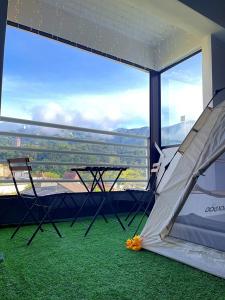 ゲンティンハイランドにあるCamp in Style with Indoor Balcony Adventures at Gentingの大きな窓の前にテーブルとスライドが付いた部屋