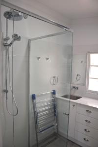 eine Glasdusche im Bad mit Waschbecken in der Unterkunft Christina Cottage - Bring your own linen in South West Rocks + 22 Fotos