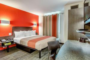 a hotel room with a bed with an orange wall at Motel 6-Saskatoon, SK in Saskatoon +17 photos