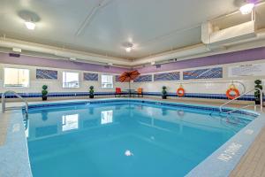 een zwembad met blauw water in een grote kamer bij Motel 6-Saskatoon, SK in Saskatoon