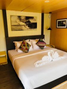 a bedroom with a bed with towels on it at Chick Resort Khao Kho in Khao Kho