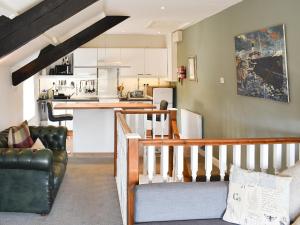 a living room with a couch and a kitchen at Writers Cottage - Uk33475 in Nenthead