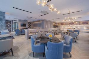 un ristorante con sedie e tavoli blu e un bar di Echarm Hotel Nanning East Railway Station a Tunli