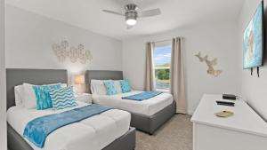 ein Schlafzimmer mit zwei Betten und einer Couch in der Unterkunft Stunning Townhouses 5 Minutes away Disney! in Kissimmee
