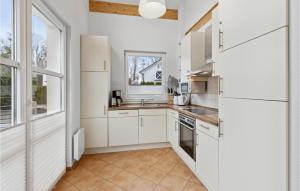 une cuisine avec des armoires blanches et une fenêtre dans l'établissement Seebrise B, à Süssau