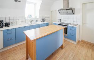 a kitchen with blue cabinets and a wooden counter top at Stunning Apartment In Samsø With Wifi in Kolby Kås