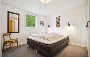 a bedroom with a bed and a chair in it at Holiday Home Fyrvej Rømø Iii in Bolilmark