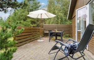 a patio with a table and an umbrella at Holiday Home Fyrvej Rømø Iii in Bolilmark +17 photos