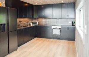 a kitchen with black cabinets and a wooden floor at Nice Home In Treungen With Kitchen in Treungen