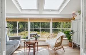 a living room with windows and a couch and a table at 2 Bedroom Amazing Home In Nexø in Neksø