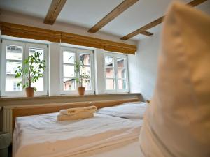 a bedroom with a bed with three windows at Hotel am Schloß in Schwerin