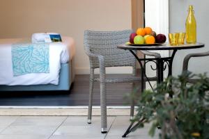 a table with a bowl of fruit and a table with a chair at Hotel La Villa Del Mare in Cagliari