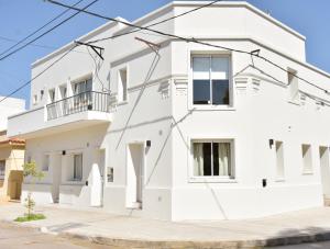 a white house on a street at Las Blanquitas- departamentos en el casco histórico de Chascomús, a pocos metros de la laguna in Chascomús