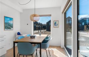 a dining room with a wooden table and blue chairs at Kysthusene, Lejl 7 in Slagelse