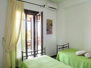 two beds in a white room with a window at Stunning seafront apartment in Kea in Korissia