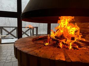 a fire pit in a room with flames at Yama Lodge Madarao in Madarao Kogen