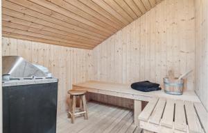 a wooden sauna with a bench and a stove at Beautiful Home In Nexø With Kitchen in Neksø