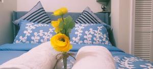 a bed with blue and white pillows and a vase with flowers at Serenity Escape in Hudson Valley in Hopewell Junction +14 photos