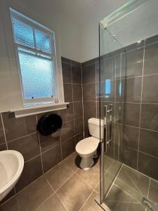 a bathroom with a toilet and a glass shower at Beaumont Hotel and Holiday Park in Lawrence +31 photos