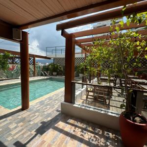 a patio with a pool and a pergola at Hotel Rodadero Relax in Gaira