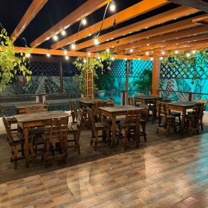 a restaurant with wooden tables and chairs and a mural at Hotel Rodadero Relax in Gaira