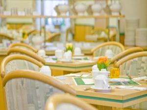 a dining room with tables and chairs with flowers on them at Hotel am Schloß in Schwerin
