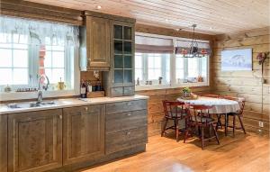 a kitchen with wooden cabinets and a table with chairs at 4 Bedroom Awesome Home In Nordfjordeid in Nordfjordeid