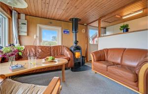 a living room with a couch and a wood stove at 1 Bedroom Awesome Home In Allingåbro in Allingåbro