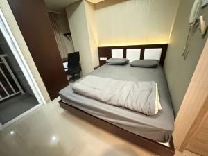 a bedroom with a large bed in a room at Taman Melati Yogyakarta Apartement 1240 in Kejayan