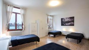 - une chambre avec 2 lits et une fenêtre dans l'établissement Silk Road, à Venise